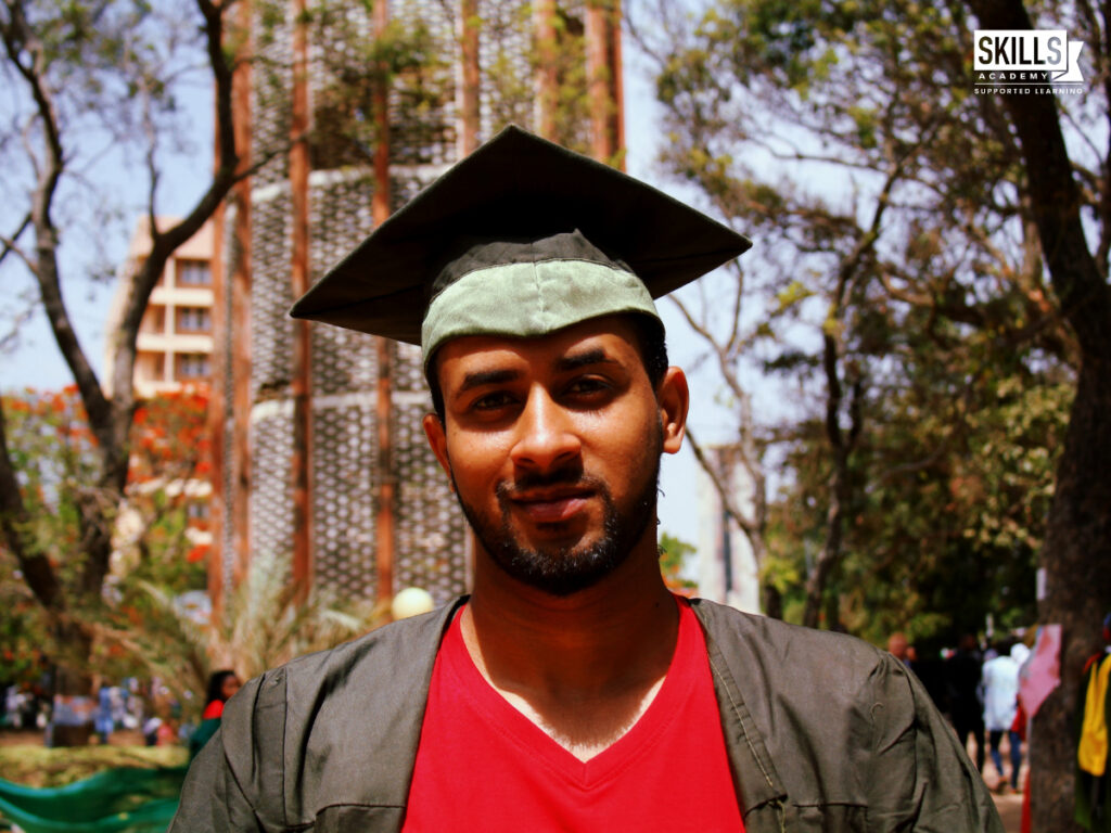 毕业生站在外面，穿着毕业礼服，戴着毕业帽。