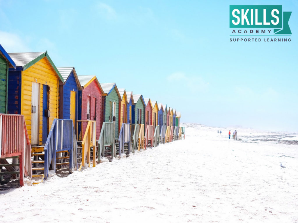 Muizenberg海滩上的小木屋。学习技能，你需要带游客在南非各地旅游与我们的旅游课程。