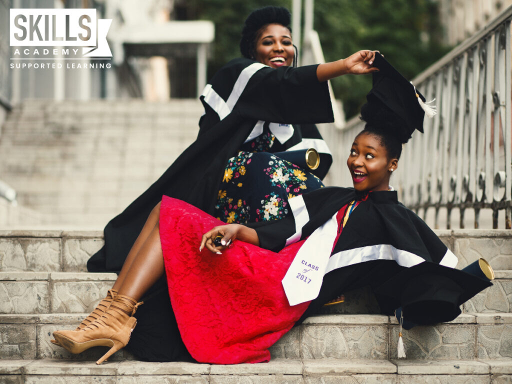 两个穿着毕业礼服的年轻女子。庆祝他们的提供者课程证书。