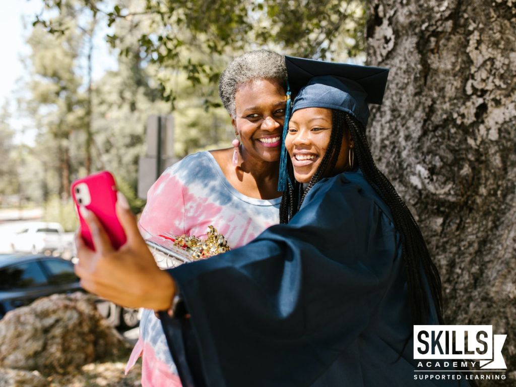 戴着毕业帽、穿着毕业礼服的女孩与母亲合影。和我们一起去拿你的入学证书。