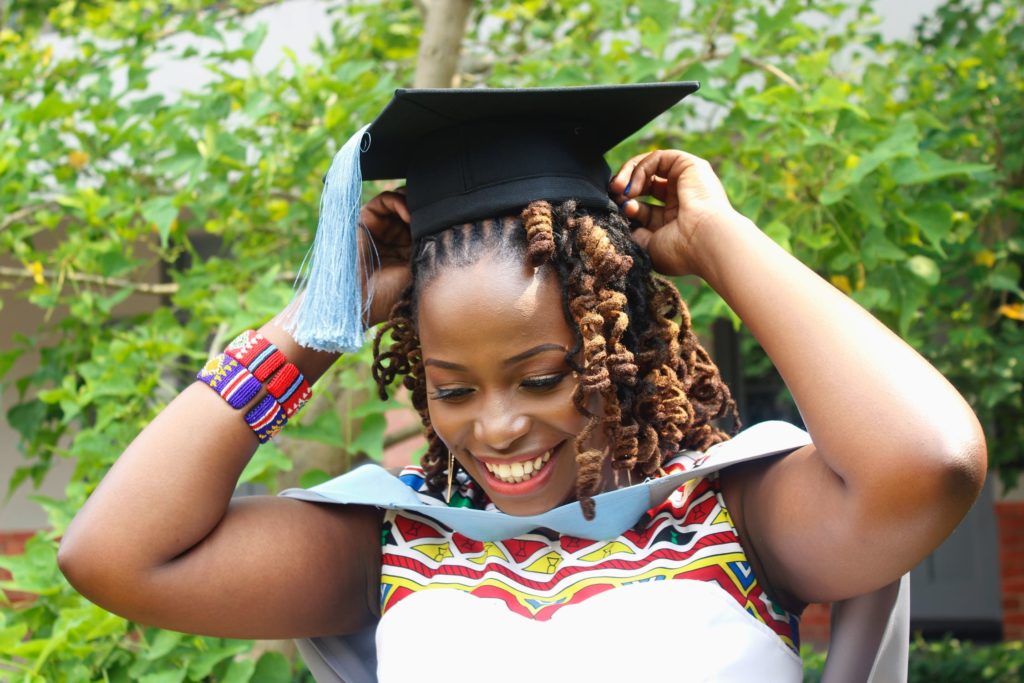 一名年轻女子在毕业典礼上笑得很开心，因为她不用担心学费。