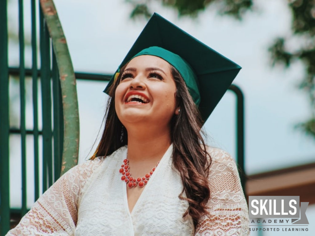 一个年轻的女孩在天空微笑在她毕业发现如何通过在线课程