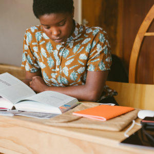一名学生坐在桌子旁，拿着书准备考试。ICB考试注册2021年