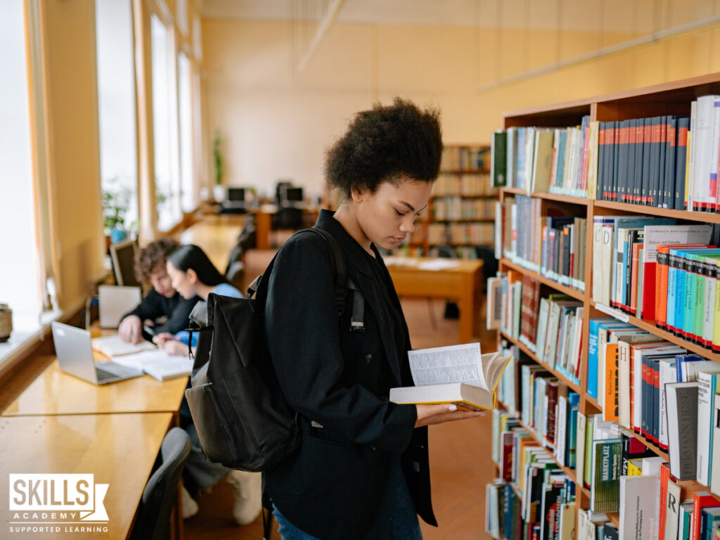 一个学生站在图书馆里看书。与我们的ICB招股书2022加快所有ICB的速度。