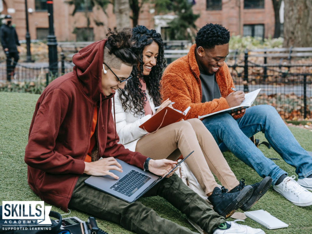 三个学生坐在外面学习。了解所有关于国家文凭学习的好处。