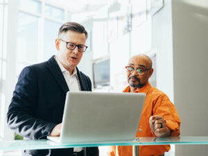 工作时两个人站在一台笔记本电脑。银行独立委员会2022年招股说明书