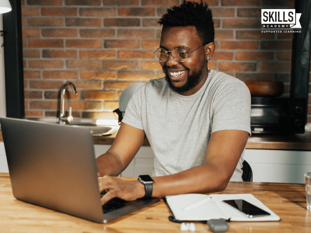 一个人对着他的笔记本电脑微笑。2022年最值得学习的金融工作
