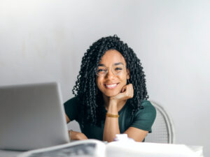 女孩在她的笔记本电脑后面微笑。我在南非哪里可以学习ICB课程?