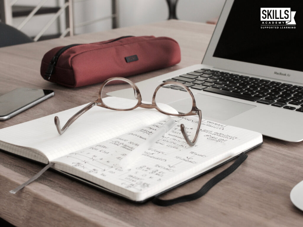 笔记本和眼镜的一台笔记本电脑。学习会计的好处。