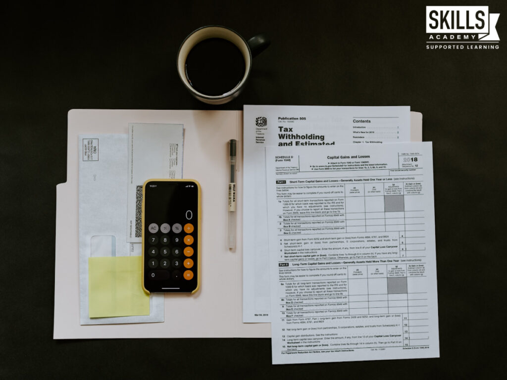 计算器和税收形式放在桌上。研究簿记课程在开普敦和更新你的技能。